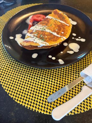 a black plate with a sandwich on a table at Caribean Seascape in Villas del Mar