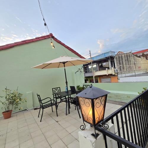 a patio with an umbrella and a table and chairs at Napoli Centro in Santa Ana