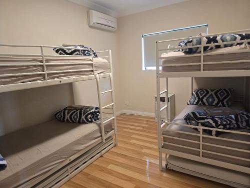 a room with three bunk beds in it at Dune View in Lancelin