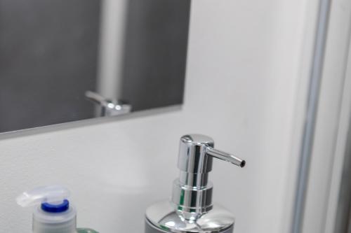 a bathroom sink with a faucet and a mirror at St James Court Aparthotel in Derby