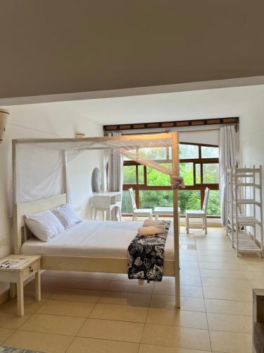 a bedroom with a canopy bed and a ladder at Golden Sun in Diani Beach