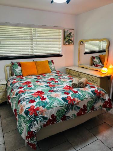 a bedroom with a bed with a colorful comforter at The Greenhouse Effect in Corpus Christi