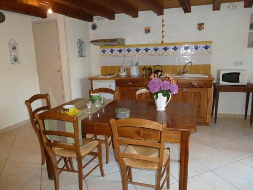 a kitchen with a wooden table and chairs and a table and a kitchen at Fleur de Vigne in Monnières