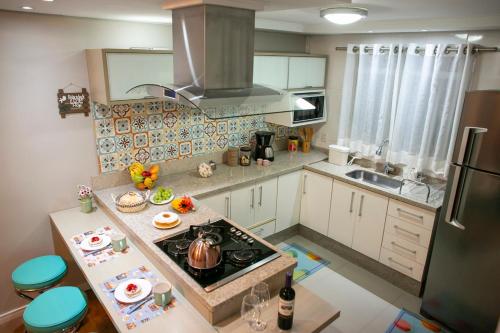 a small kitchen with a stove and a sink at B&B Apartamento Completo e Decorado com 3 Quartos in São José dos Pinhais