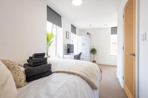 a white bedroom with a bed with towels on it at St James Court Aparthotel in Derby