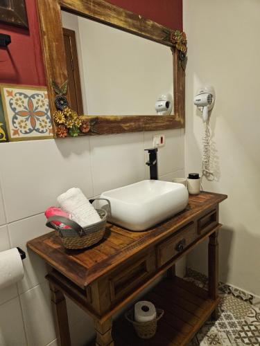 a bathroom with a white sink and a mirror at Pousada de Charme Emirados in Ilhabela