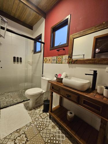 a bathroom with a sink and a shower and a toilet at Pousada de Charme Emirados in Ilhabela