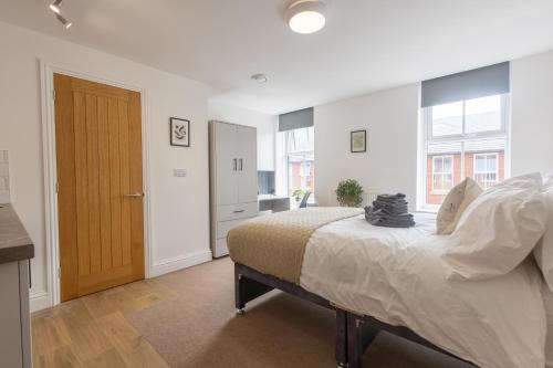 a bedroom with a bed and a wooden door at St James Court Aparthotel in Derby