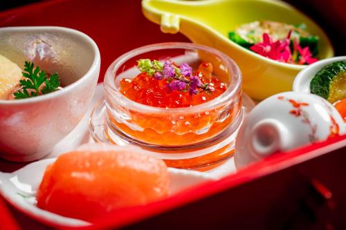 ein Tablett mit einer Schüssel Essen und einer Schale Obst in der Unterkunft Hotel Premium Lake TOYA in Tōya-See