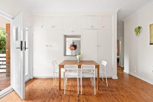 jadalnia z drewnianym stołem i białymi szafkami w obiekcie Chic Double Room - Seconds to Transport & Shops at Killara - Shared Bathroom w mieście Killara