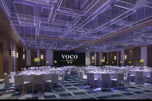 a conference room with tables and chairs and a vico sign at voco Bangkok Surawong by IHG in Bangkok