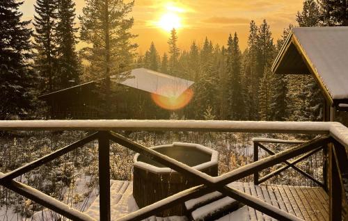 a view of a snow covered forest with the sun setting at Cozy Home In Vemdalen With Sauna in Vemdalen