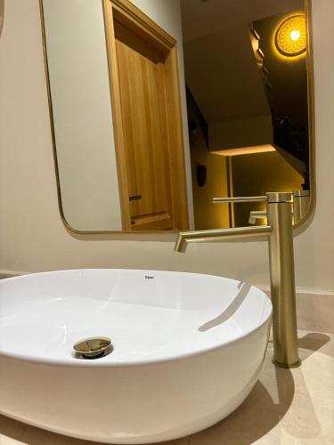 a white sink in a bathroom with a mirror at Riad Villa Alain mohamed V airport in Nouaceur