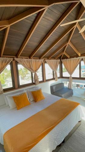 a bedroom with a large bed and some windows at Isla Sol Boutique in Puerto Villamil