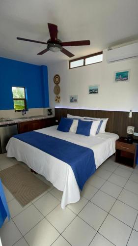 a bedroom with a large bed with a ceiling fan at Isla Sol Boutique in Puerto Villamil