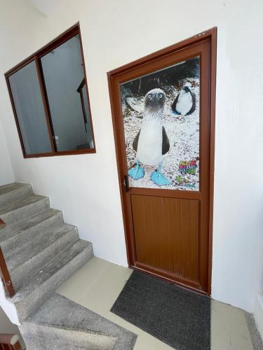 a penguin standing in front of a door at Isla Sol Boutique in Puerto Villamil