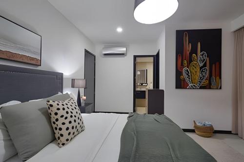 a bedroom with a large white bed in a room at Beachside 1BDR Dreamy Apt.| BBQ + Pool & Sea View in Juan Dolio