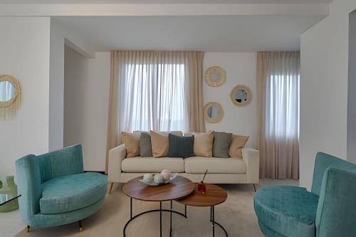 a living room with a couch and two chairs and a table at Beachside 1BDR Dreamy Apt.| BBQ + Pool & Sea View in Juan Dolio