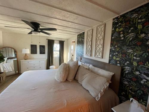 a bedroom with a white bed with a ceiling fan at Scenic Ranch Retreat Near Fresno in Fresno