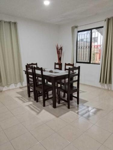 a dining room with a table and chairs and a window at Casa Amelia Victoria in Mérida