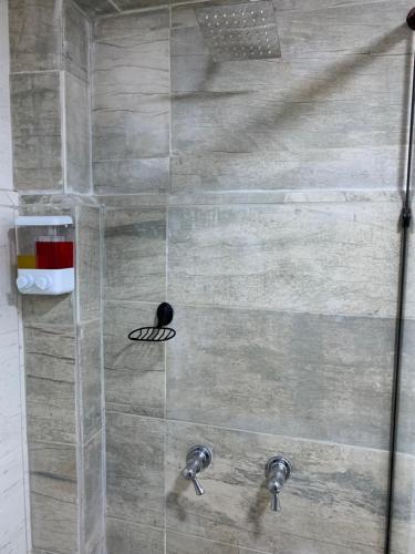 a shower with two faucets in a bathroom at Casa Samor La Candelaria in Bogotá