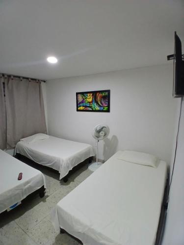 a room with two beds and a fan at Hotel PalmaLinda in Palmira