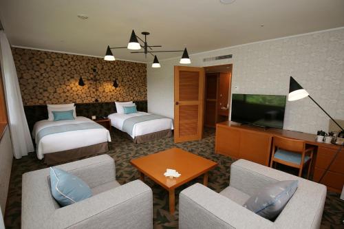 a hotel room with two beds and a television at Karuizawa Prince Hotel East in Karuizawa