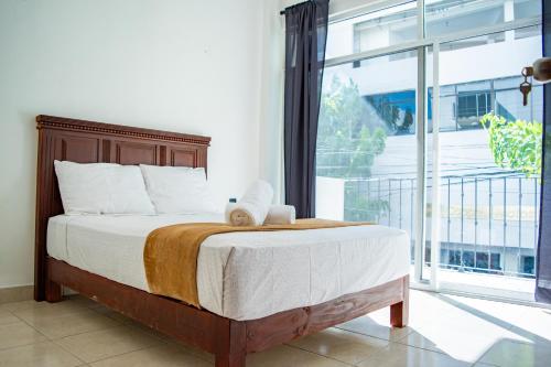 a bedroom with a bed and a large window at Hotel Catedral Jojutla in Jojutla