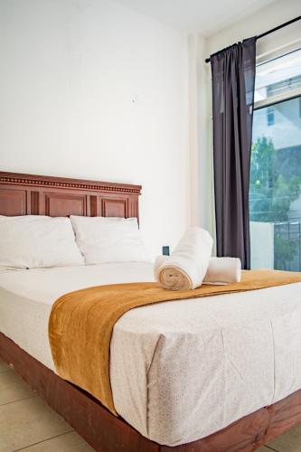 a bedroom with a large bed with a window at Hotel Catedral Jojutla in Jojutla