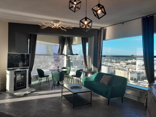 sala de estar con sofá verde y chimenea en SEA TOWERS TOP 28 th FLOOR! PANORAMIC Sea & City VIEWS from Glass Corner SKY TRIANGLE PENTHOUSE! Terrace! Sailing in the heaven feels like a King!, en Gdynia