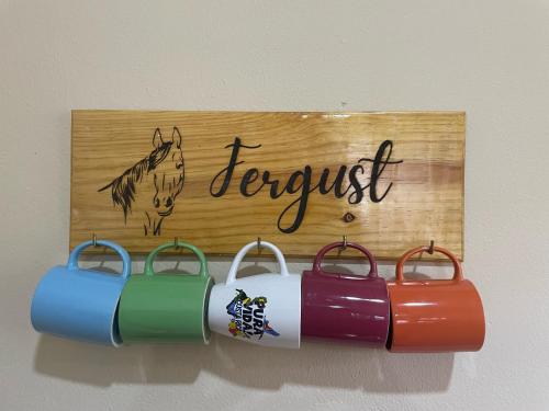 a sign with three wine buckets on a wall at Fergust Family Studio Monteverde in Sierra