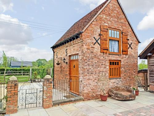 a brick building with a gate and a fence at The Stable in Welland