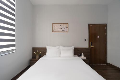 a bedroom with a large bed with white pillows at Scenery Hotel DaLat in Da Lat