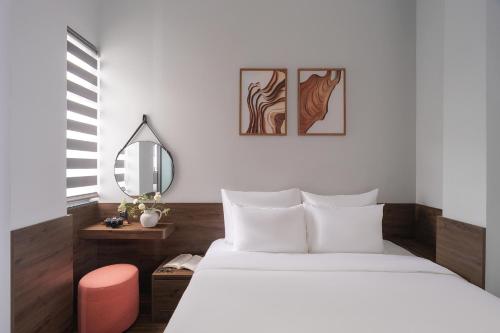 a bedroom with a white bed and a mirror at Scenery Hotel DaLat in Da Lat