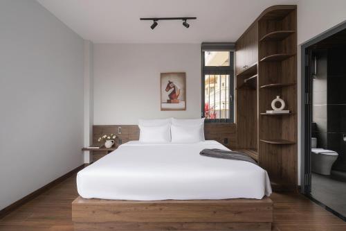 a bedroom with a large white bed and a bathroom at Scenery Hotel DaLat in Da Lat