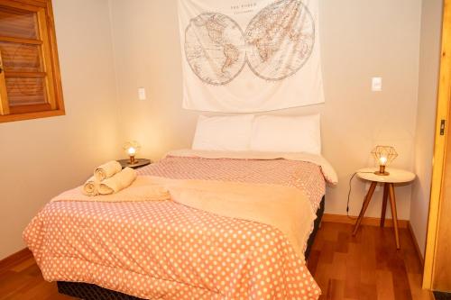 a small bedroom with a bed and two lamps at Villa da Serra - Casa 02 in São Bento do Sapucaí