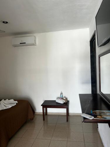 バジャドリドにあるHotel casa Don Alfonsoのベッド、テーブル、テレビが備わる客室です。