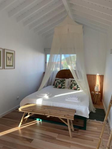 a bedroom with a bed with a mosquito net at Garden Loft in Ribeira Grande