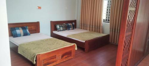 a bedroom with two beds and a window at Hồng Ân Motel Quảng Trị in Quảng Trị