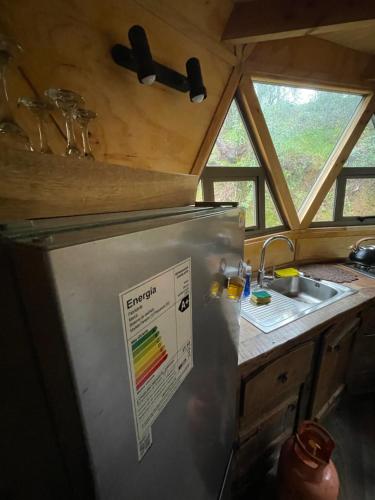 a refrigerator in a kitchen with a sink and a window at Domo Tralcao Valdivia 