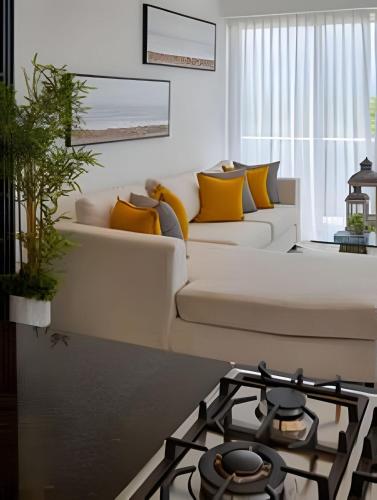 a living room with a white couch and a stove at Beachside Heaven Sea View 1bdrm Apartment in Juan Dolio