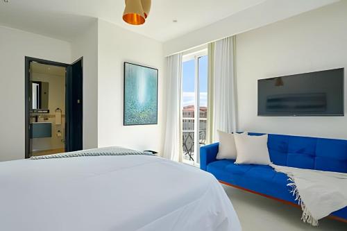 a bedroom with a blue bed and a blue couch at Beachside Heaven Sea View 1bdrm Apartment in Juan Dolio