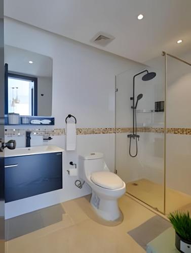 a bathroom with a toilet and a sink and a shower at Beachside Heaven Sea View 1bdrm Apartment in Juan Dolio