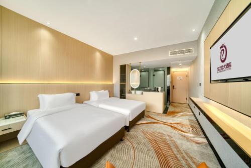 a hotel room with two beds and a flat screen tv at 温州乐清龙之梦大酒店 in Hengdaiqiao