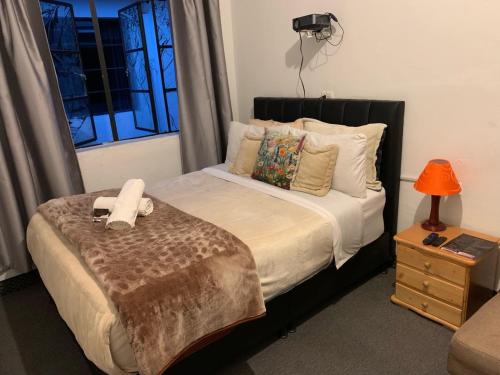 a bedroom with a bed with a blanket and a window at Casa Samor La Candelaria in Bogotá