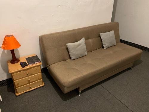 a couch with two pillows and a table with a lamp at Casa Samor La Candelaria in Bogotá