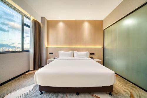 a bedroom with a large white bed and a large window at 温州乐清龙之梦大酒店 in Hengdaiqiao
