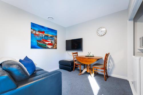 a living room with a blue couch and a table at Shiloh Luxury Retreat in Wakefield