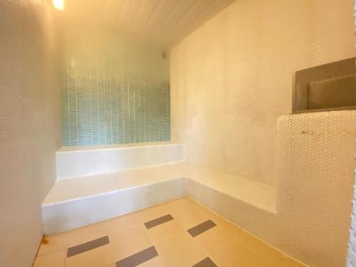 a white bathroom with a tub and a window at Karuizawa Prince Hotel East in Karuizawa