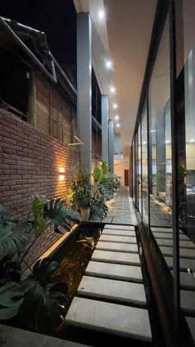 a hallway of a building with a pond and plants at Samu Bac Ha Hotel in Lao Cai